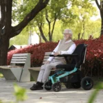 Elderly man sitting outdoors on the Golden Ally GP303 power chair smiling in a park setting