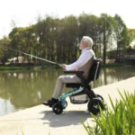 Elderly man fishing by the water while seated on the Golden Ally GP303 power chair