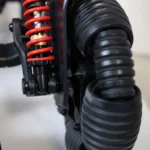 Close-up of the red suspension spring and wheel assembly of the Golden Ally Pro GP304 highlighting the shock absorption system for a smoother ride.