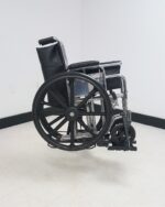Side profile of a manual wheelchair riding in the Tilt N Tote Model 001